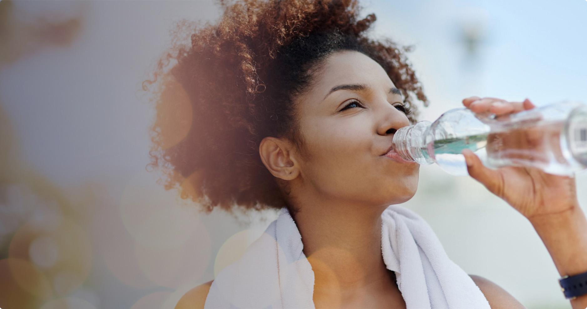 A woman drinking water after exercising