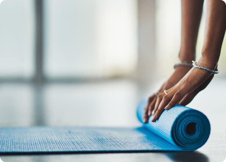 A person rolling up their yoga mat