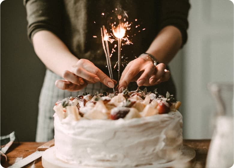 A birthday cake with sparkler candles lit