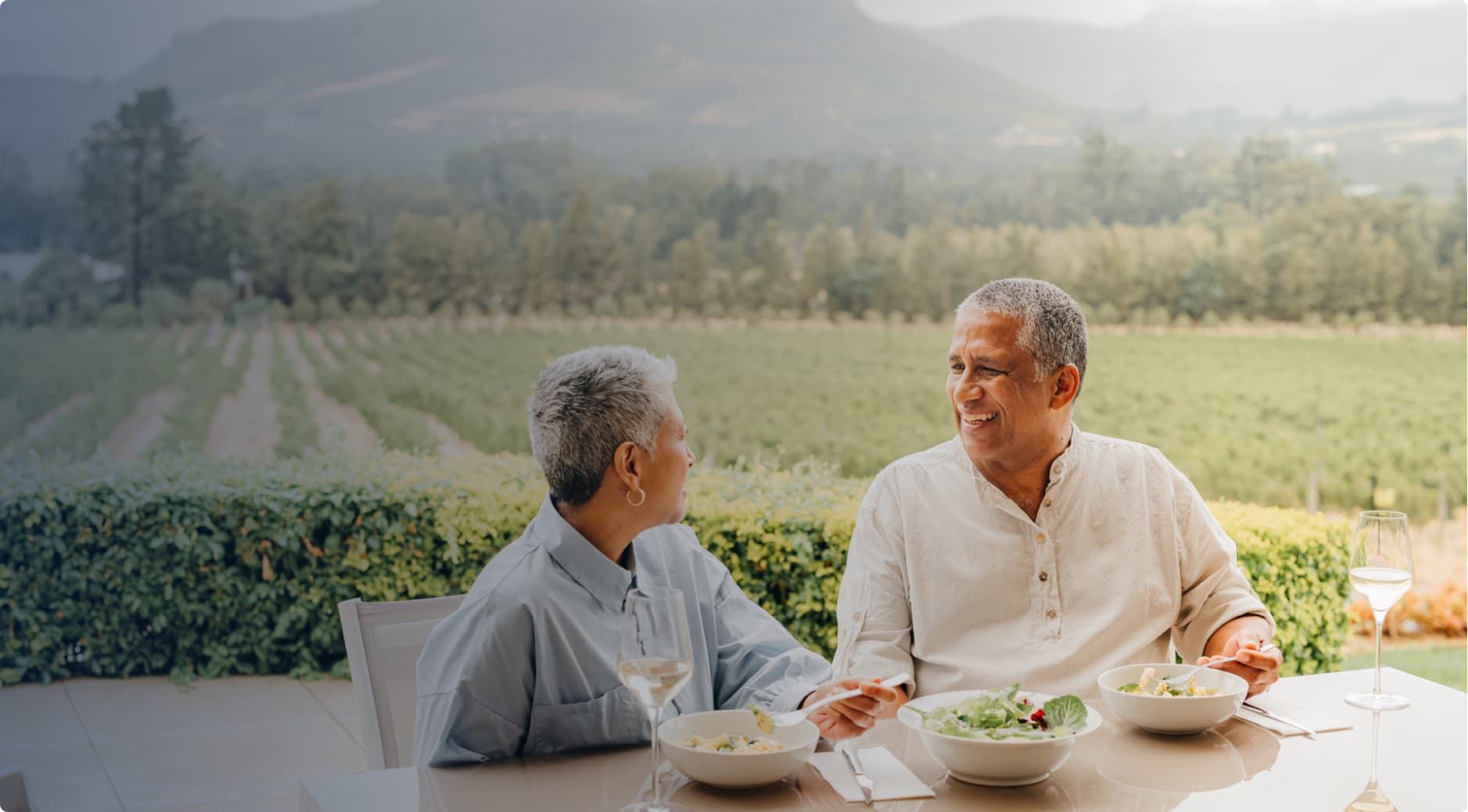 A woman and man eating lunch in a vineyard