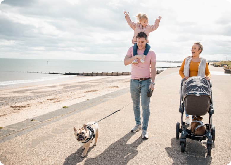 A family walking their dog near the beach